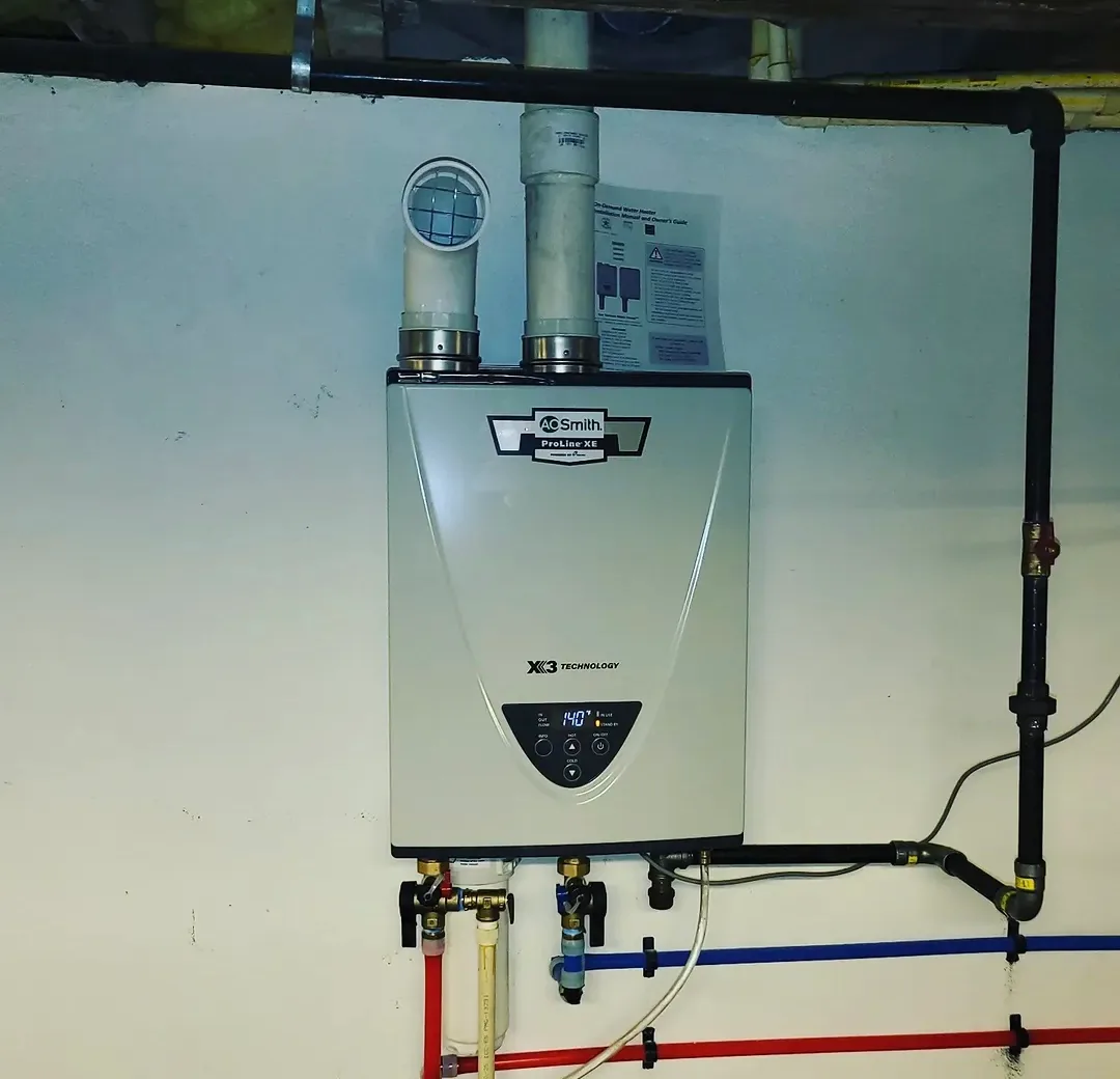 A wall-mounted high-efficiency water heater with its flue and gas shut-off in a northern New Jersey utility room