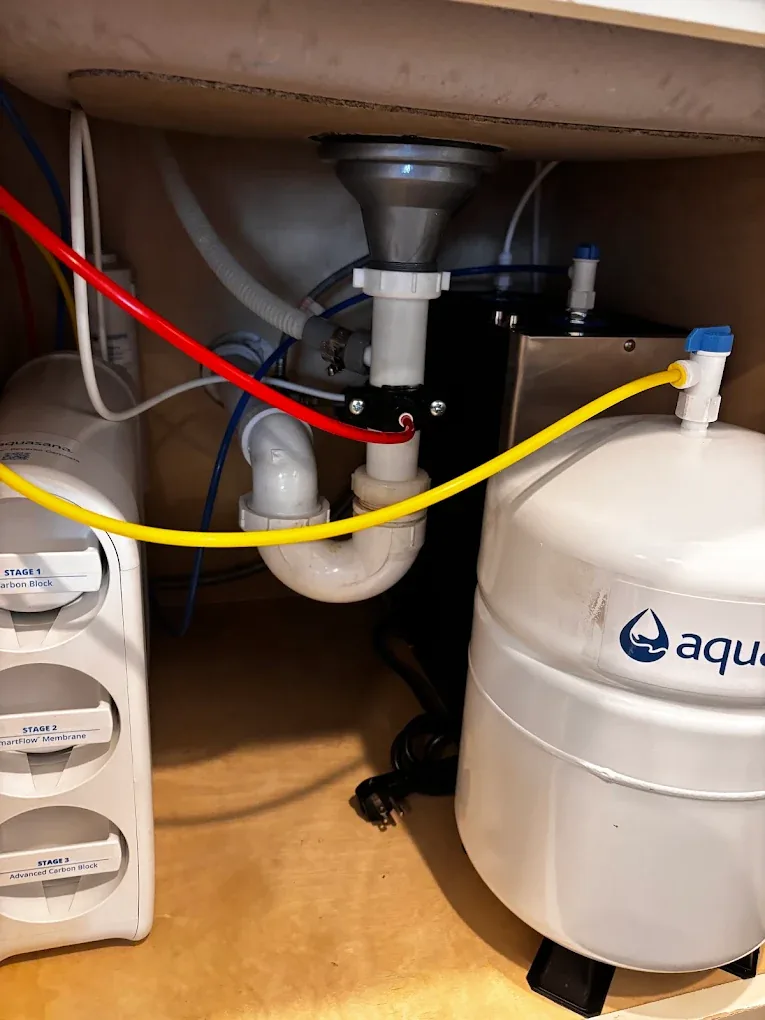 A multi-stage reverse osmosis drinking water system installed under a kitchen sink