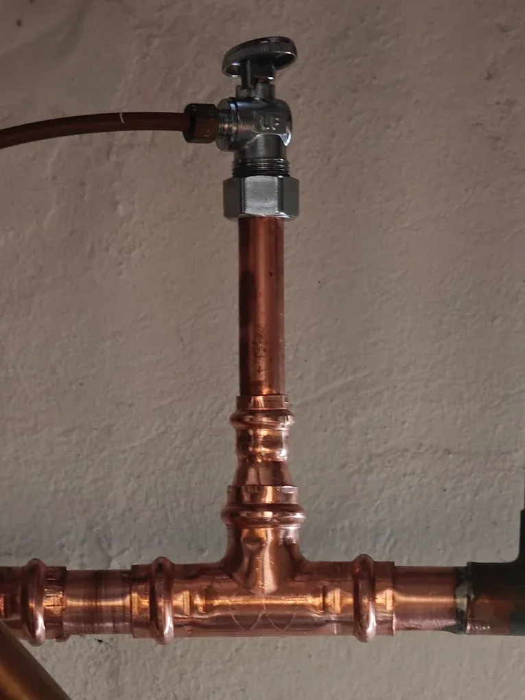 A soldered copper tee and shut-off valve on a newly run water line