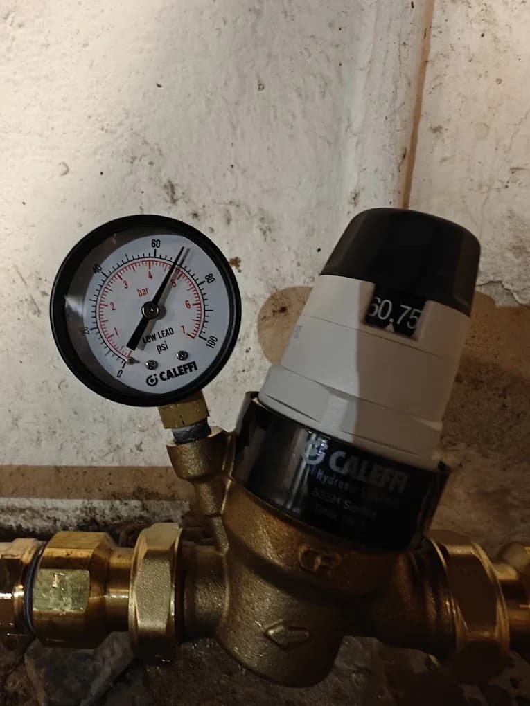 A Caleffi pressure reducing valve with an inline pressure gauge fitted to a brass water service line