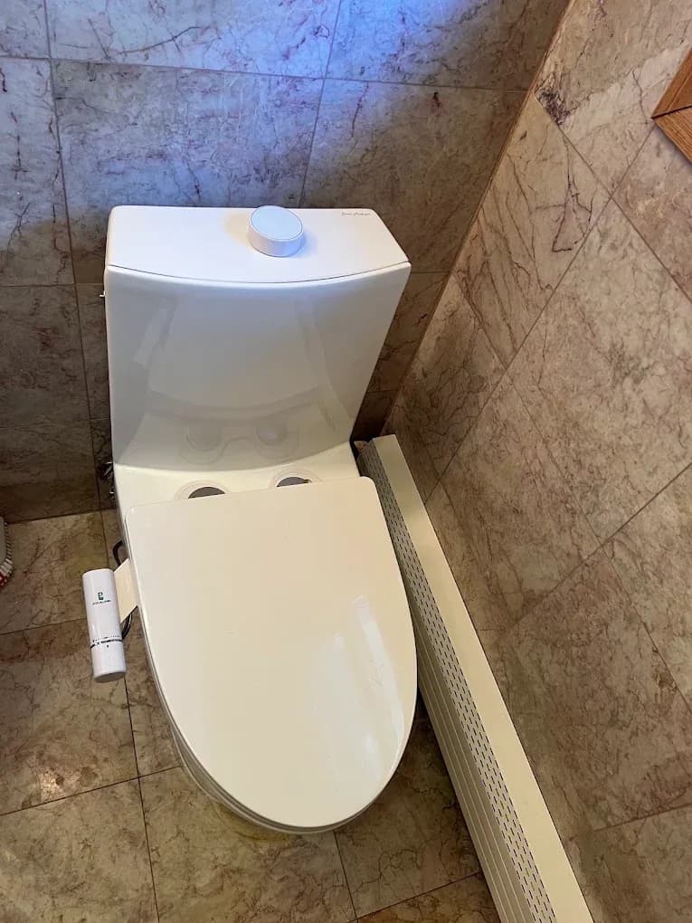 A new toilet set out on the bathroom floor part-way through a replacement