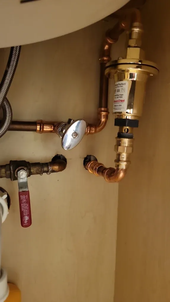Copper water lines, shut-off valves and an inline treatment cartridge on a finished assembly