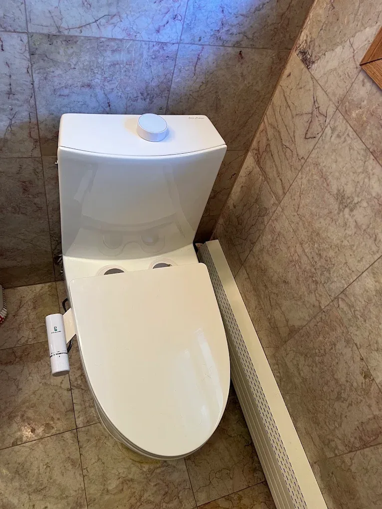 A new toilet set out on the bathroom floor part-way through a replacement